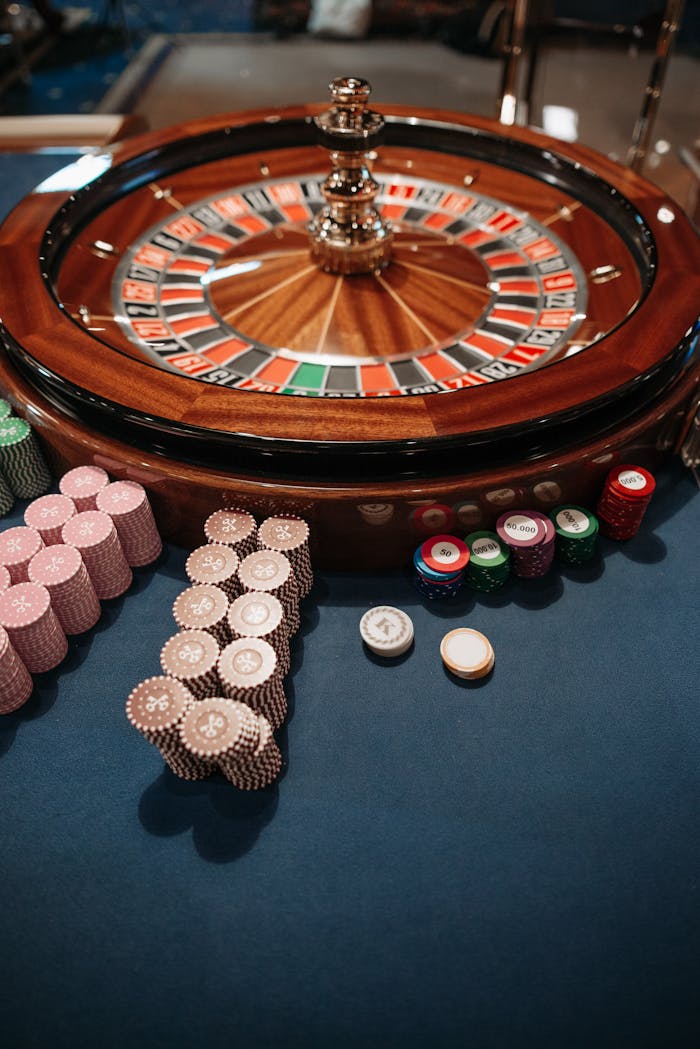 about-02 Roulette wheel on table with neatly stacked poker chips, capturing the essence of a casino.